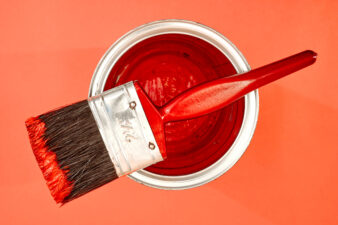 paint brush on top of red paint