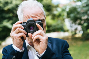 old man holding a camera