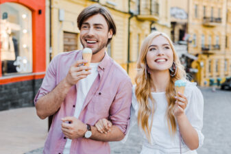 young couple walking and eating ice cream cones