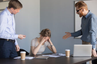 Angry businessmen shouting at female colleague
