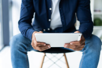 man sitting on a stool looking at a tablet