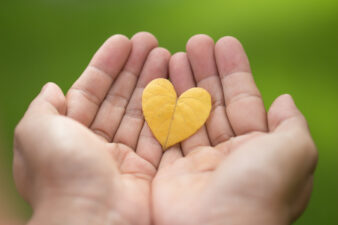 closeup of hands holding a yellow heart