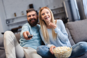 happy couple watching a movie together at home