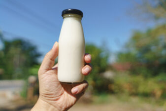 hand holding glass bottle of milk