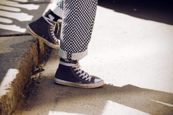 legs wearing plaid pants and black Converse