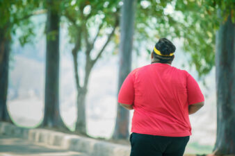 back view of an obese man going on a run
