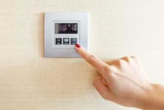 woman pressing a thermostat