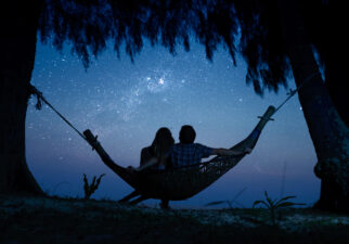 couple sitting on a hammock looking at the stars
