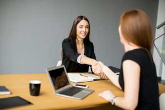 business women shaking hands over a meeting table