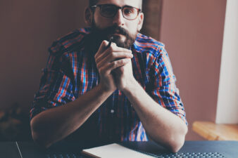 bearded man with pen and notebook