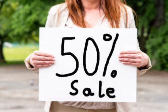 woman holding a sale sign