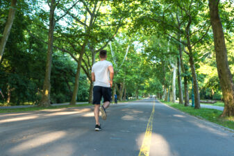 back view of a young man jogging down the road