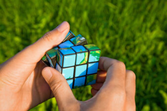 hands playing with an Earth print Rubik's Cube