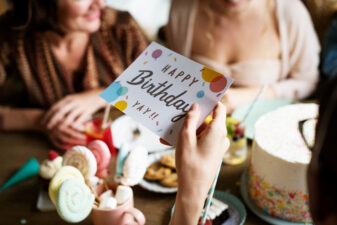 woman's hand holding a happy birthday card