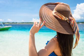 woman wearing a floppy sun hat at the beach