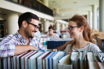 man and woman smiling at each other at a library