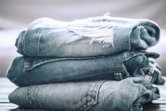 A stack of jeans on a wooden background