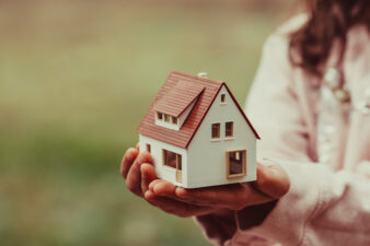 a woman holding a small house