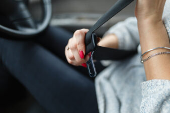 woman putting on her seatbelt