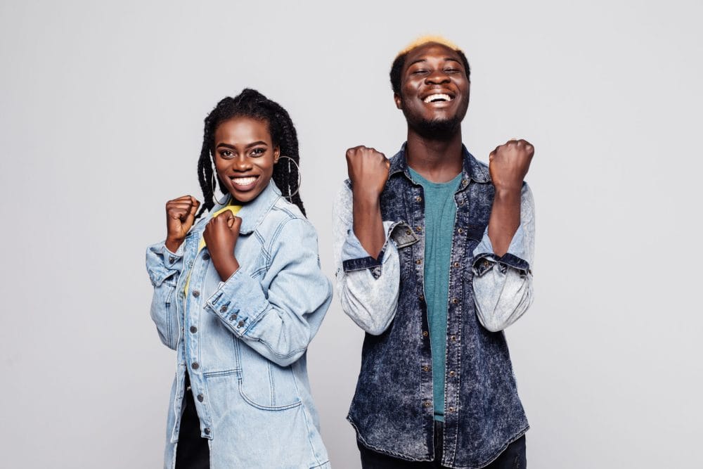 Portrait of a happy young afro american couple screaming and celebrating isolated over white background